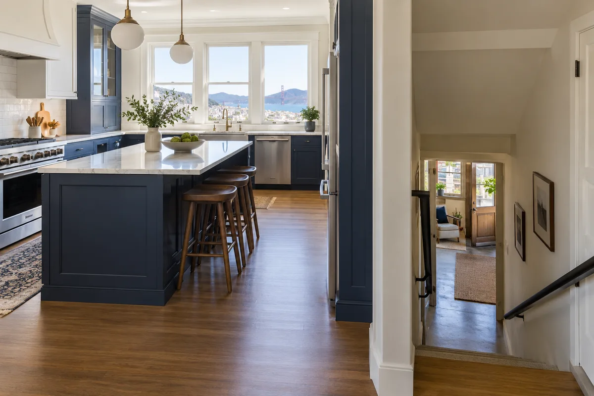 San Francisco rowhouse interior with kitchen upstairs and lower-level stair doorway visible.